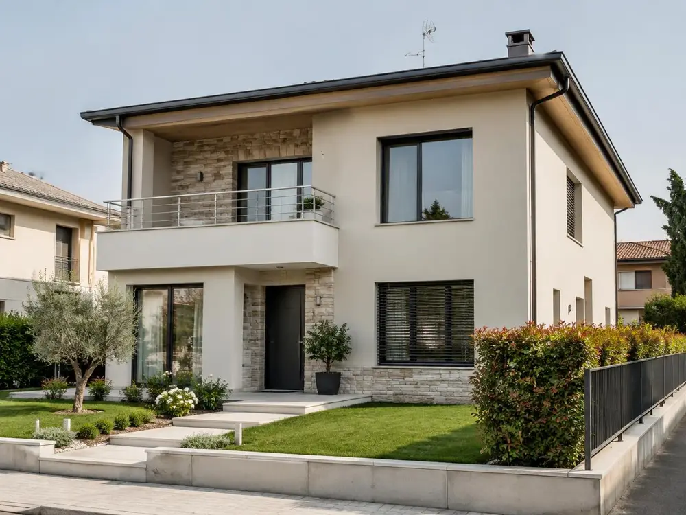 Casa contemporanea a due piani con intonaco chiaro e dettagli in pietra